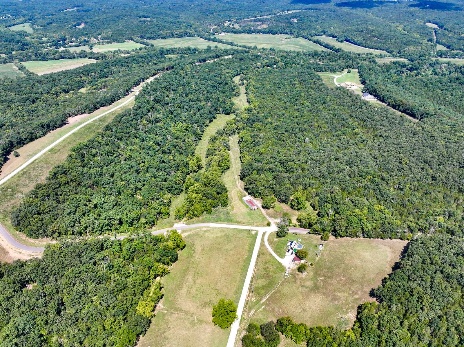 Aerial of Tanglefoot Farm showing gravel roads, open pasture, and wooded ridges